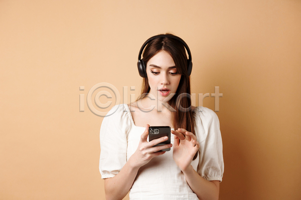 성인 성인여자한명만 여자 한명 JPG 앞모습 포토 해외이미지 노래감상 놀람 들기 상반신 스마트폰 실내 헤드셋