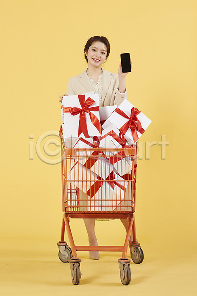20대 성인 성인여자한명만 여자 한국인 한명 JPG 앞모습 포토 노란배경 노란색 리본 미소(표정) 상자 서기 선물 쇼핑 쇼핑카 스마트폰 스튜디오촬영 실내 전신
