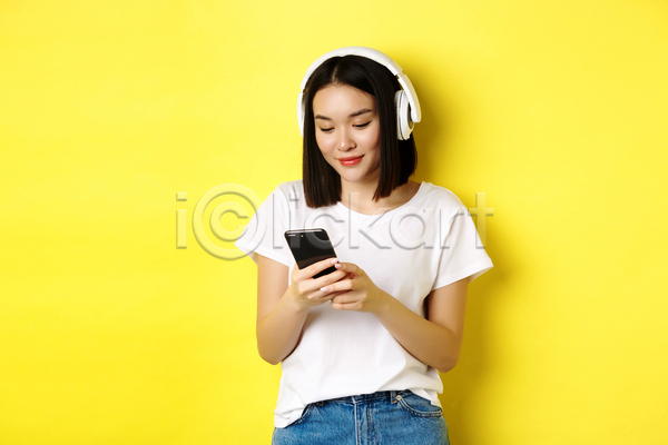 즐거움 동양인 성인 성인여자한명만 여자 한명 JPG 앞모습 포토 해외이미지 노래감상 들기 상반신 스마트폰 실내 웃음 헤드셋