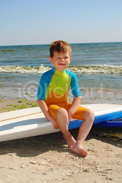 남자 소년 소년한명만 어린이 한명 JPG 앞모습 포토 해외이미지 그림자 바다 서핑보드 수영복 수평선 앉기 야외 윙크 전신 주간 하늘 해변