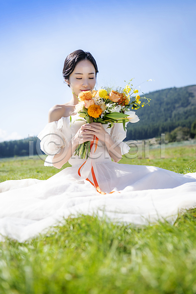 행복 20대 성인 성인여자한명만 여자 한국인 한명 JPG 소프트포커스 앞모습 포토 결혼 냄새 눈감음 들기 부케 신부(웨딩) 앉기 야외 웨딩드레스 웨딩촬영 전신 제주도 주간 초원(자연) 하늘 향기