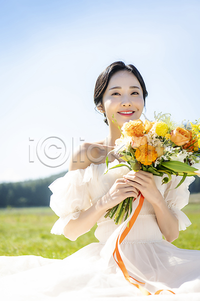 행복 20대 성인 성인여자한명만 여자 한국인 한명 JPG 앞모습 포토 결혼 들기 미소(표정) 부케 상반신 신부(웨딩) 앉기 야외 웨딩드레스 웨딩촬영 응시 제주도 주간 초원(자연) 하늘