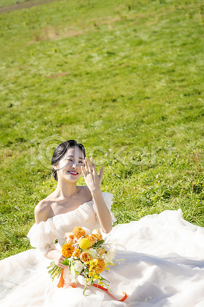 행복 20대 성인 성인여자한명만 여자 한국인 한명 JPG 앞모습 포토 결혼 결혼반지 들기 미소(표정) 보여주기 부케 상반신 신부(웨딩) 앉기 야외 웨딩드레스 웨딩촬영 응시 자랑 제주도 주간 초원(자연)