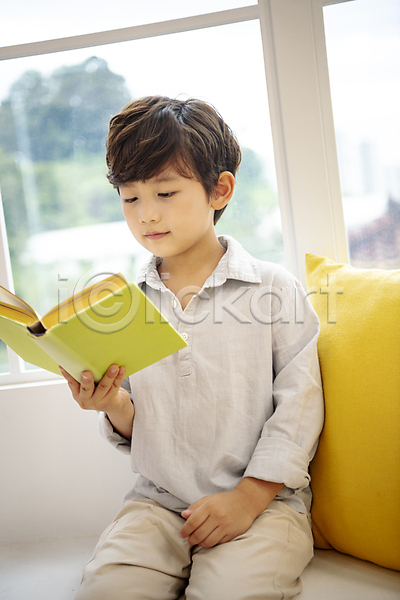 휴식 남자 소년 소년한명만 어린이 한국인 한명 JPG 앞모습 포토 거실 독서 들기 미소(표정) 상반신 실내 아들 앉기 어린이라이프 응시 의자 창문 책 쿠션