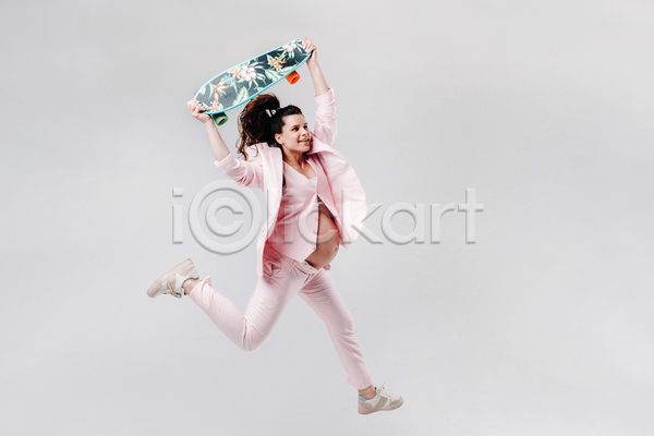 성인 성인여자한명만 여자 한명 JPG 옆모습 포토 해외이미지 들기 스케이트보드 실내 엄마 임산부 임신 전신 점프 정장 흰배경