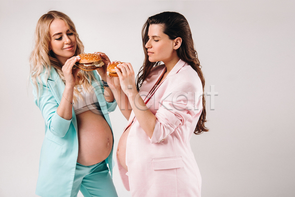 두명 성인 성인여자만 여자 JPG 옆모습 포토 해외이미지 들기 상반신 실내 엄마 응시 임산부 임신 정장 햄버거 흰배경