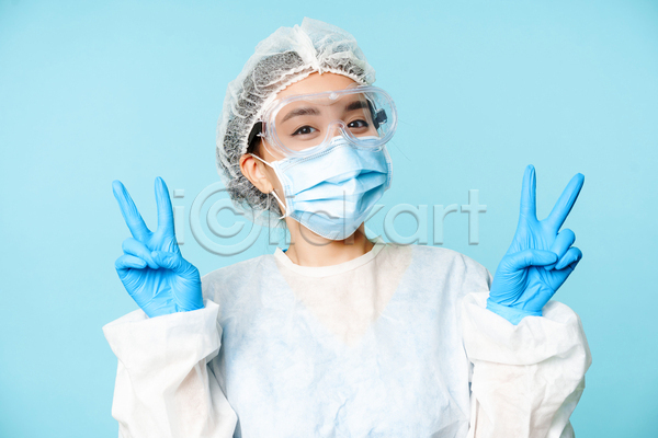 동양인 성인 성인여자한명만 여자 한명 JPG 앞모습 포토 해외이미지 마스크 방역복 브이 상반신 실내 의료진 의사 파란배경
