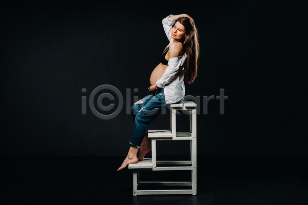 우아함 성인 성인여자한명만 여자 한명 JPG 옆모습 포토 해외이미지 걸터앉기 검은배경 계단 눈감음 셔츠 실내 임산부 임신 전신 청바지 포즈