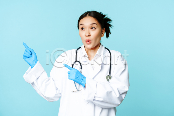 동양인 성인 성인여자한명만 여자 한명 JPG 앞모습 포토 해외이미지 가리킴 놀람 상반신 실내 응시 의료진 의사 청진기 파란배경