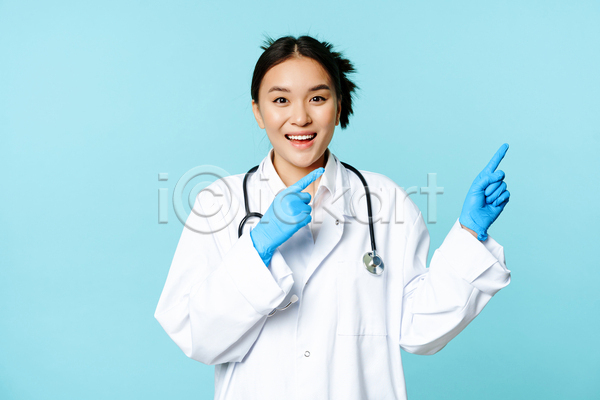 동양인 성인 성인여자한명만 여자 한명 JPG 앞모습 포토 해외이미지 가리킴 상반신 실내 웃음 의료진 의사 청진기 파란배경
