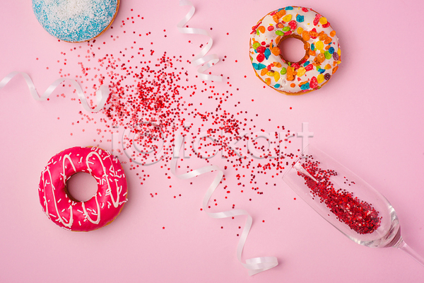 사람없음 JPG 포토 하이앵글 해외이미지 더스트파티클 도넛 리본 반짝임 분홍색배경 샴페인잔 실내 쏟아짐 토핑