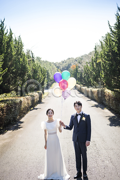 사랑 행복 20대 30대 남자 두명 성인 성인만 여자 한국인 JPG 앞모습 포토 결혼 나무길 미소(표정) 서기 신랑신부 야외 웨딩드레스 웨딩촬영 응시 전신 정장 제주도 주간 턱시도 풍선 풍선잡기