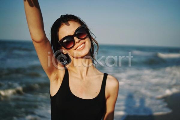 여유 휴식 성인 성인여자한명만 여자 한명 JPG 아웃포커스 앞모습 포토 해외이미지 미소(표정) 바캉스 상반신 선글라스 손들기 야외 여름(계절) 여름휴가 주간 해변