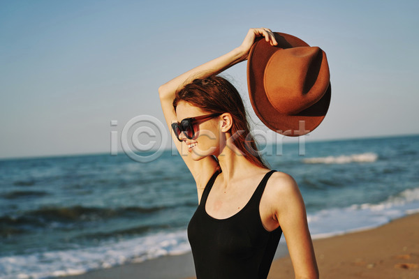 여유 휴식 성인 성인여자한명만 여자 한명 JPG 옆모습 포토 해외이미지 들기 모자(잡화) 미소(표정) 바캉스 상반신 선글라스 야외 여름(계절) 여름휴가 주간 해변