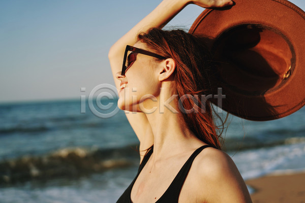 여유 휴식 성인 성인여자한명만 여자 한명 JPG 아웃포커스 옆모습 포토 해외이미지 들기 모자(잡화) 미소(표정) 바캉스 상반신 선글라스 야외 여름(계절) 여름휴가 주간 해변
