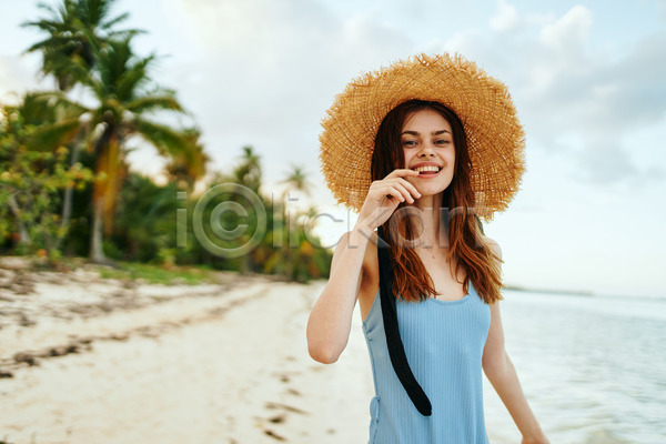 여유 즐거움 휴식 성인 성인여자한명만 여자 한명 JPG 아웃포커스 앞모습 포토 해외이미지 밀짚모자 바캉스 상반신 손들기 수영복 야외 여름(계절) 여름휴가 웃음 응시 주간 해변