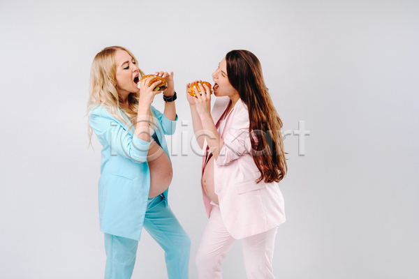 두명 성인 성인여자만 여자 JPG 옆모습 포토 해외이미지 들기 마주보기 먹기 상반신 실내 엄마 임산부 임신 입벌림 정장 흰배경