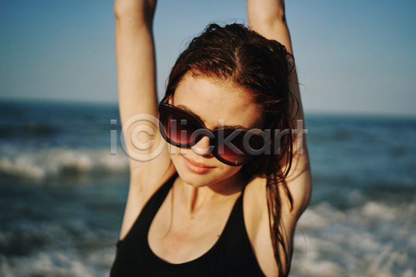 여유 휴식 성인 성인여자한명만 여자 한명 JPG 아웃포커스 앞모습 포토 해외이미지 기지개 미소(표정) 바캉스 상반신 선글라스 야외 여름(계절) 여름휴가 주간 해변