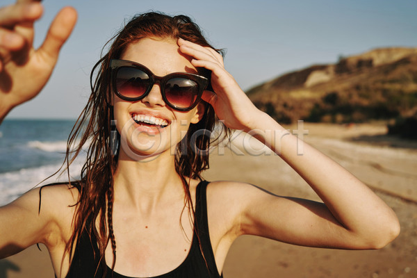 여유 즐거움 휴식 성인 성인여자한명만 여자 한명 JPG 아웃포커스 앞모습 포토 해외이미지 미소(표정) 바캉스 상반신 선글라스 손들기 야외 여름(계절) 여름휴가 주간 해변