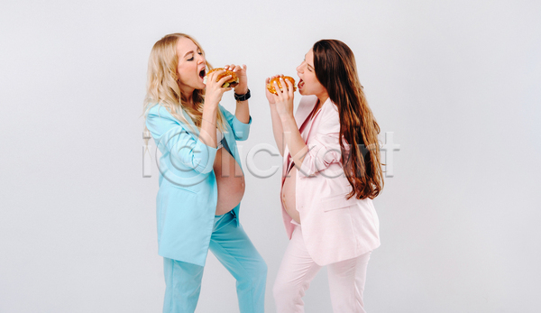 두명 성인 성인여자만 여자 JPG 옆모습 포토 해외이미지 들기 마주보기 먹기 상반신 실내 엄마 임산부 임신 입벌림 정장 흰배경