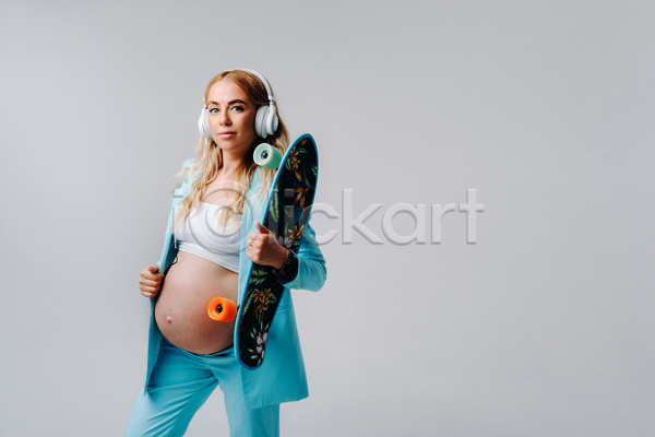 성인 성인여자한명만 여자 한명 JPG 옆모습 포토 해외이미지 들기 상반신 스케이트보드 실내 엄마 응시 임산부 임신 잡기 정장 헤드셋 흰배경