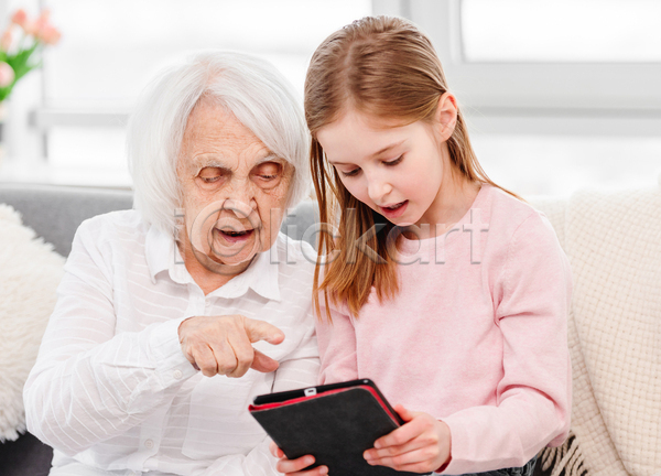 노년 두명 소녀(어린이) 어린이 여자 여자만 JPG 아웃포커스 포토 해외이미지 가리킴 가족 들기 미소(표정) 상반신 손녀 실내 응시 조부모 태블릿 할머니