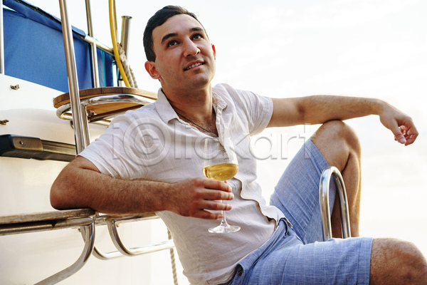 휴식 남자 백인 성인 성인남자한명만 한명 JPG 앞모습 옆모습 포토 해외이미지 들기 미소(표정) 바캉스 상반신 앉기 여름(계절) 여름휴가 와인잔 요트 응시 화이트와인