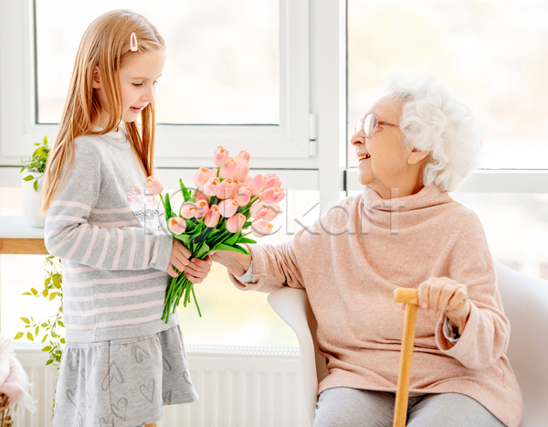 노년 두명 소녀(어린이) 어린이 여자 여자만 JPG 포토 해외이미지 가족 꽃 들기 마주보기 미소(표정) 상반신 서기 손녀 실내 앉기 의자 조부모 지팡이 창문 할머니