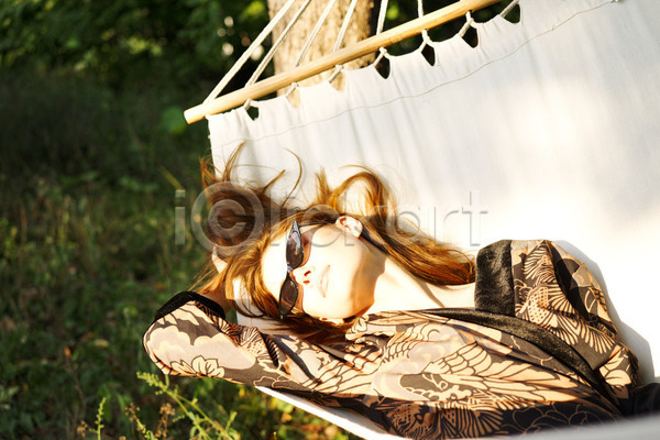백인 성인 성인여자한명만 여자 한명 JPG 아웃포커스 앞모습 포토 해외이미지 그림자 나무 눕기 상반신 선글라스 야외 응시 자연 주간 해먹 햇빛