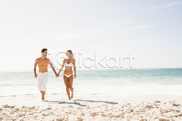 사랑 함께함 행복 20대 남자 두명 백인 여자 JPG 포토 해외이미지 걷기 관리 맑음 모래 미소(표정) 바다 비치웨어 비키니 수영복 야외 여름(계절) 커플 파도 해외202004 휴가