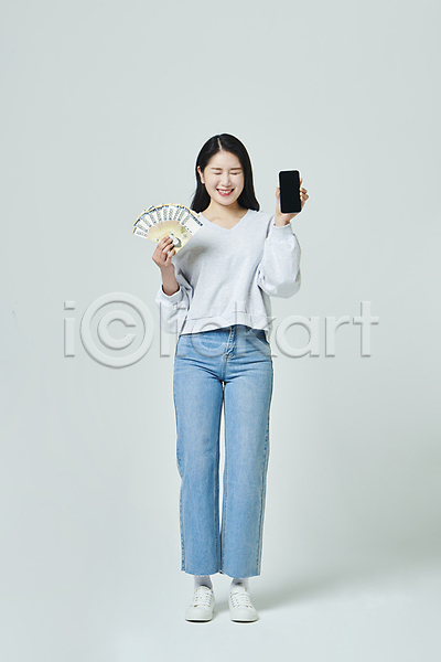 즐거움 20대 성인 성인여자한명만 여자 한국인 한명 JPG 앞모습 포토 눈감음 돈부채 들기 미소(표정) 보여주기 서기 쇼핑 스마트폰 스튜디오촬영 실내 오만원 우먼라이프 전신 지폐 회색배경