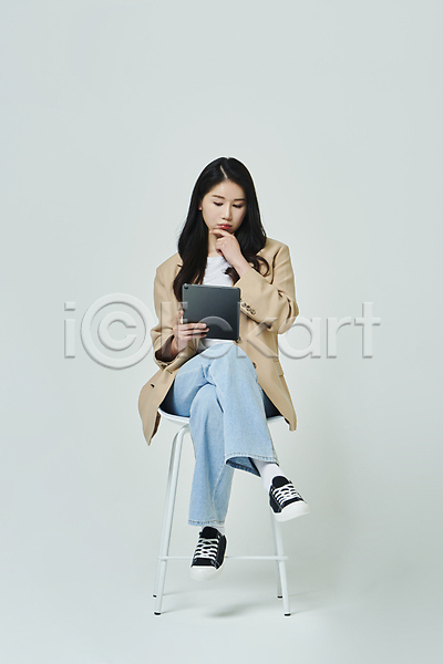 고민 20대 성인 성인여자한명만 여자 한국인 한명 JPG 앞모습 포토 다리꼬기 들기 무표정 비즈니스라이프 비즈니스우먼 생각 스튜디오촬영 실내 앉기 우먼라이프 응시 의자 전신 캐주얼 태블릿 턱괴기 회색배경