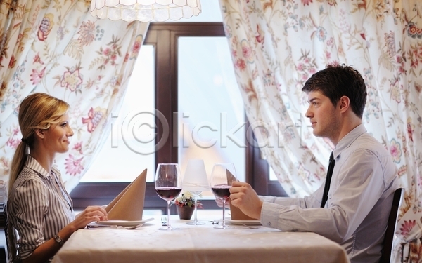 함께함 행복 남자 두명 성인 성인만 여자 JPG 옆모습 포토 해외이미지 데이트 레스토랑 마주보기 미소(표정) 상반신 손짓 식사 실내 앉기 연애 와인 커플 탁자