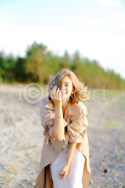 따뜻함 만족 자유 행복 휴식 백인 사람 여자 한명 JPG 포토 해외이미지 1 금발 나무 드레스 모래 미소(표정) 바다 야외 여름(계절) 유럽 유행 자연 코트 하늘 혼자 휴가 흰색