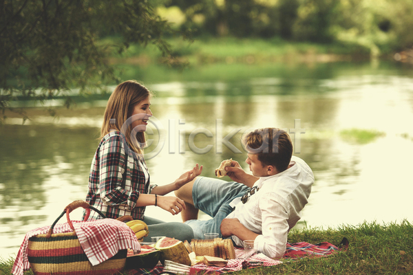 함께함 행복 휴식 남자 두명 성인 성인만 여자 JPG 옆모습 포토 해외이미지 강 공원 눕기 돗자리 라이프스타일 소풍 소풍바구니 앉기 야외 전신 주간 커플
