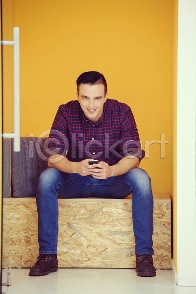 남자 성인 성인남자한명만 한명 JPG 앞모습 포토 해외이미지 노란색 들기 벽 비즈니스맨 사무실 스마트폰 앉기 업무 전신