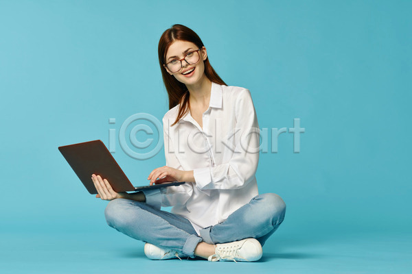 백인 성인 성인여자한명만 여자 한명 JPG 앞모습 포토 해외이미지 노트북 들기 안경낌 앉기 응시 전신 컴퓨터 타이핑 하늘색