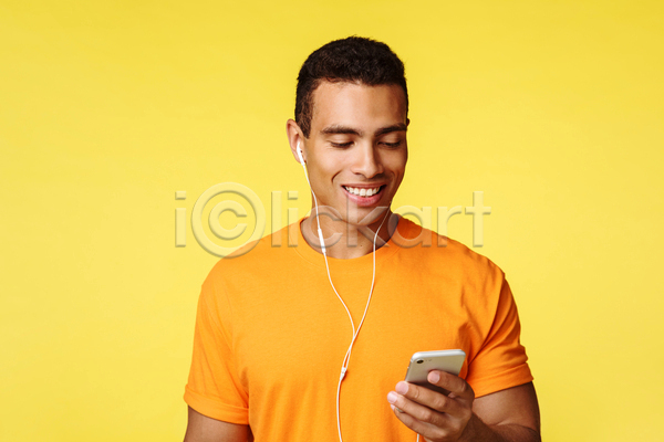 남자 성인 성인남자한명만 한명 JPG 앞모습 포토 해외이미지 노란색 들기 상반신 스마트폰 실내 음악감상 이어폰