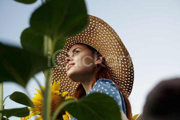 성인 성인여자한명만 여자 한명 JPG 로우앵글 포토 해외이미지 미소(표정) 밀짚모자 상반신 야외 여름(계절) 잎 주간 풍경(경치) 해바라기