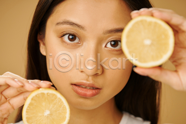 동양인 성인 성인여자한명만 여자 한명 JPG 앞모습 포토 해외이미지 갈색배경 과일조각 들기 레몬 뷰티 상반신 얼굴 응시 컨셉