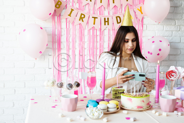 기쁨 축하 행복 백인 사람 성인 성인여자한명만 여자 한명 JPG 포토 해외이미지 고깔(모자) 들기 분홍색 사진촬영 상반신 생일 생일케이크 스마트폰 이벤트 케이크 파티 풍선