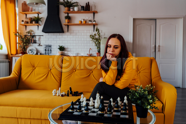 고민 성인 성인여자한명만 여자 한명 JPG 앞모습 포토 해외이미지 노란색 놀이 상반신 소파 실내 앉기 응시 체스 체스판 취미 턱괴기