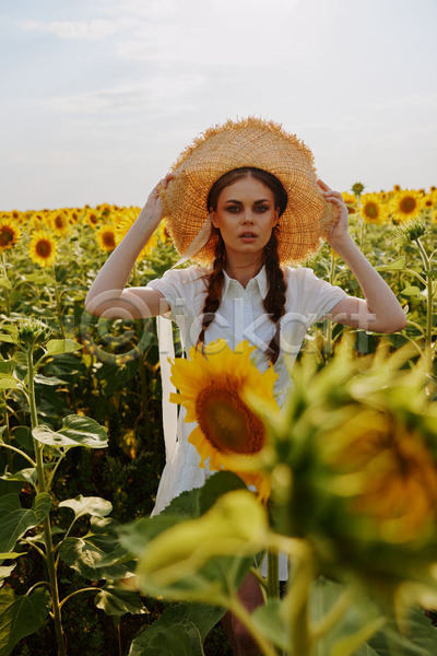 성인 성인여자한명만 여자 한명 JPG 소프트포커스 앞모습 포토 해외이미지 꽃밭 밀짚모자 상반신 야외 잡기 주간 해바라기