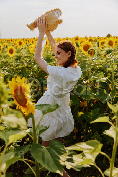 성인 성인여자한명만 여자 한명 JPG 뒷모습 포토 해외이미지 꽃밭 들기 들어올리기 미소(표정) 밀짚모자 상반신 야외 여름(계절) 주간 풍경(경치) 해바라기