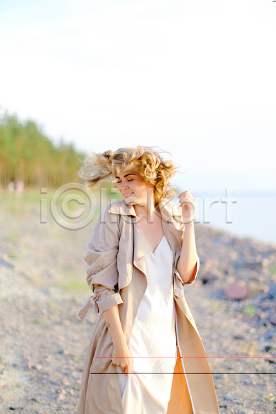 따뜻함 만족 자유 행복 휴식 백인 사람 여자 한명 JPG 포토 해외이미지 1 금발 나무 드레스 모래 미소(표정) 바다 야외 여름(계절) 유럽 유행 자연 코트 하늘 혼자 휴가 흰색