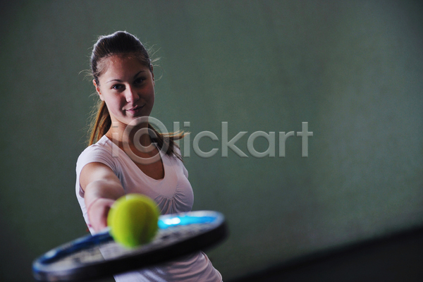 성인 성인여자한명만 여자 한명 JPG 소프트포커스 앞모습 포토 해외이미지 들기 미소(표정) 상반신 실내 어둠 응시 테니스 테니스공 테니스라켓 테니스선수