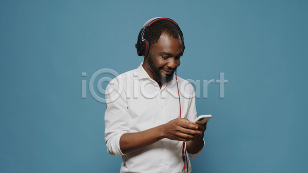 즐거움 남자 성인 성인남자한명만 한명 흑인 JPG 앞모습 포토 해외이미지 들기 상반신 스마트폰 실내 웃음 음악감상 헤드셋
