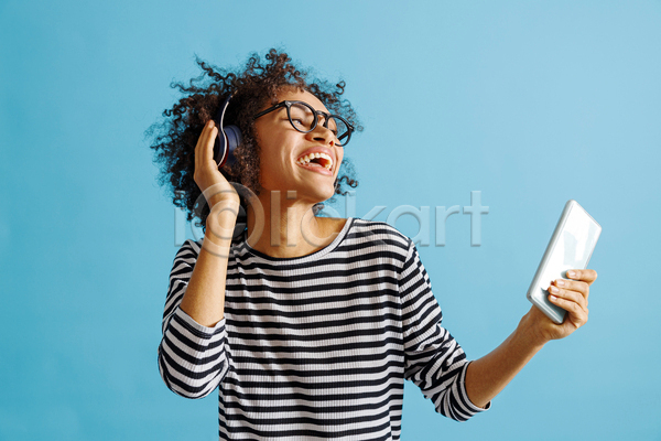 즐거움 성인 성인여자한명만 여자 한명 JPG 앞모습 포토 해외이미지 들기 상반신 스마트폰 실내 안경낌 웃음 파란배경 헤드셋