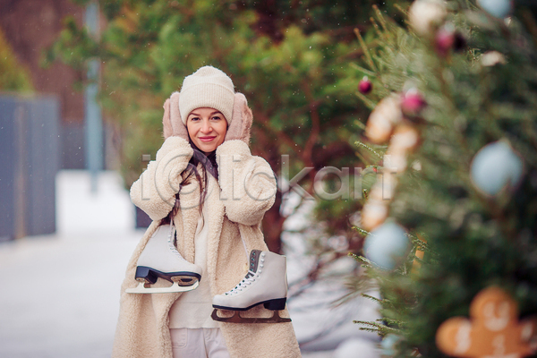 성인 성인여자한명만 여자 한명 JPG 소프트포커스 아웃포커스 앞모습 포토 해외이미지 겨울 겨울옷 귀막기 비니 상반신 스케이트 야외 응시 주간