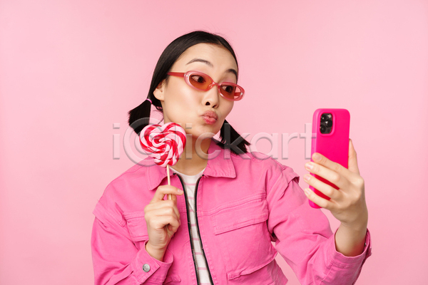 동양인 성인 성인여자한명만 여자 한명 JPG 포토 해외이미지 들기 막대사탕 분홍색배경 상반신 서기 선글라스 셀프카메라 응시